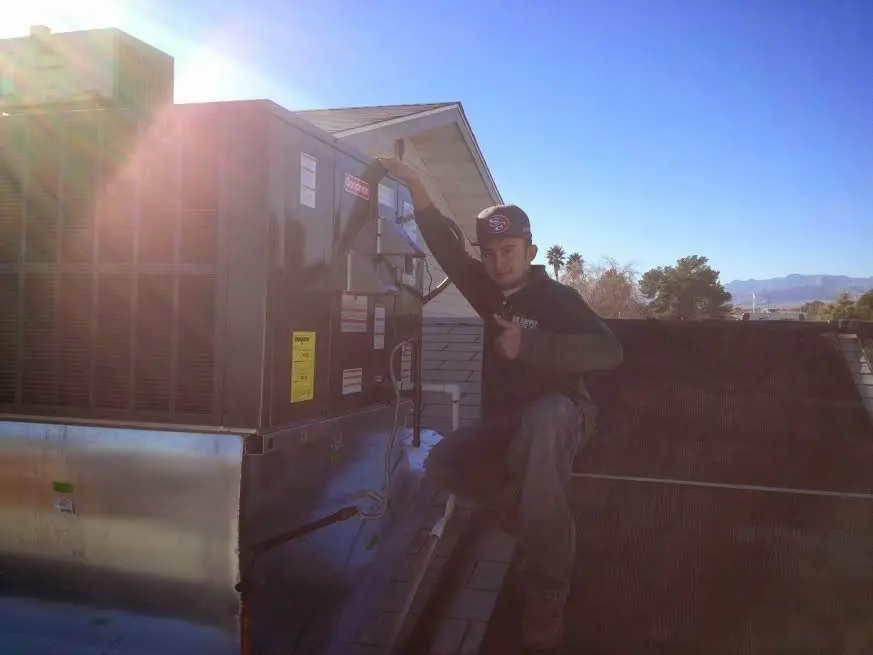 HVAC technician performing Boiler Repair on a rooftop unit in Leominster